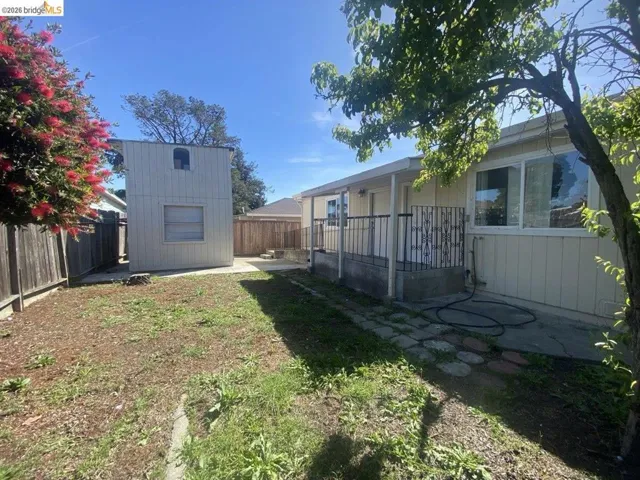 Fenced backyard with an outbuilding and a patio area