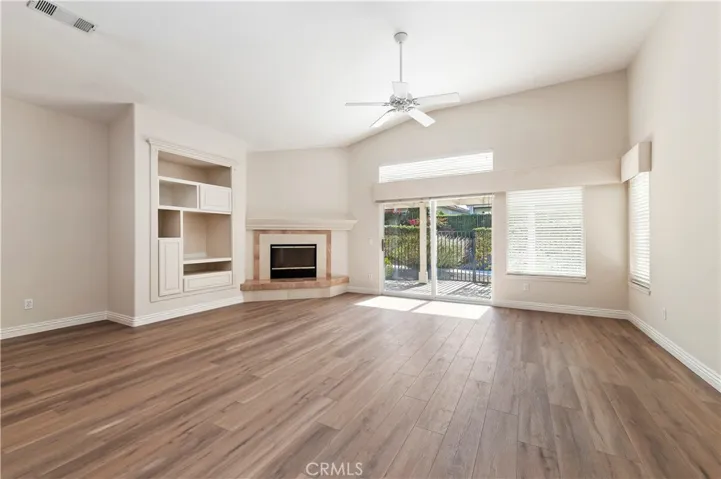 The great room offers vaulted ceilings and lots of natural light.  Note the stylish vinyl plank flooring and wide baseboards throughout the home.