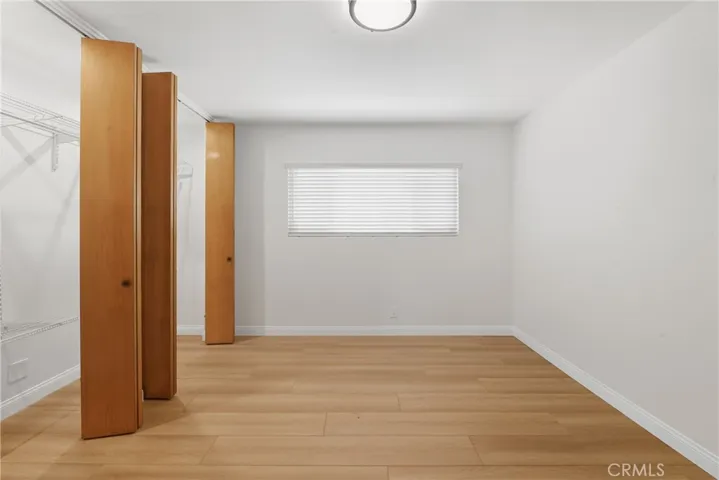 2nd bedroom with wall to wall closet and closet lighting
