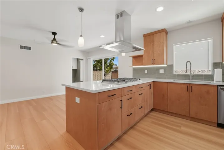 kitchen peninsula with built in cooktop and quartz counters