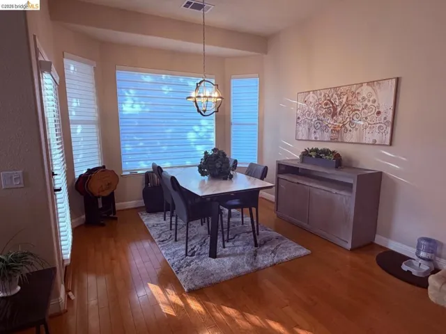 Dining space with hardwood / wood-style floors and hanging lights