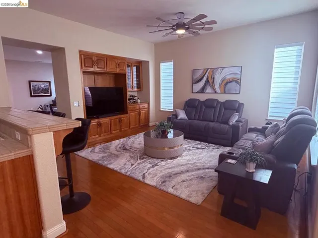 Living area with wood-type flooring and a ceiling fan
