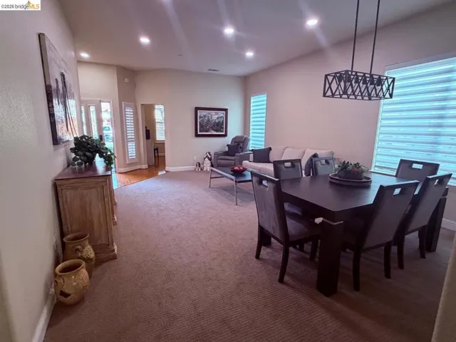 Dining space with recessed lighting and light colored carpet