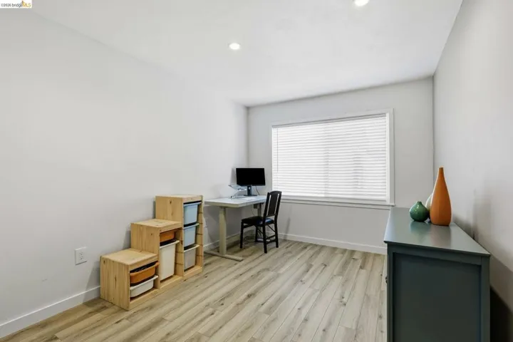 Office area with light wood-style floors and recessed lighting