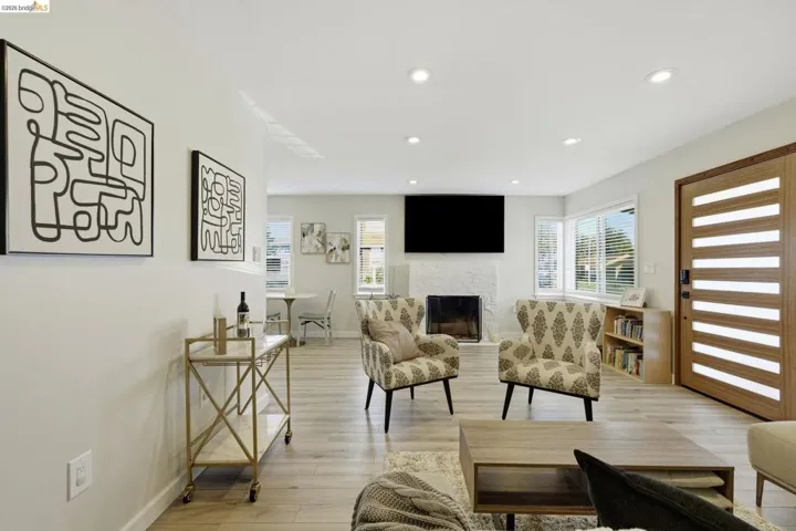 Living area featuring light wood finished floors, healthy amount of natural light, a fireplace, and recessed lighting