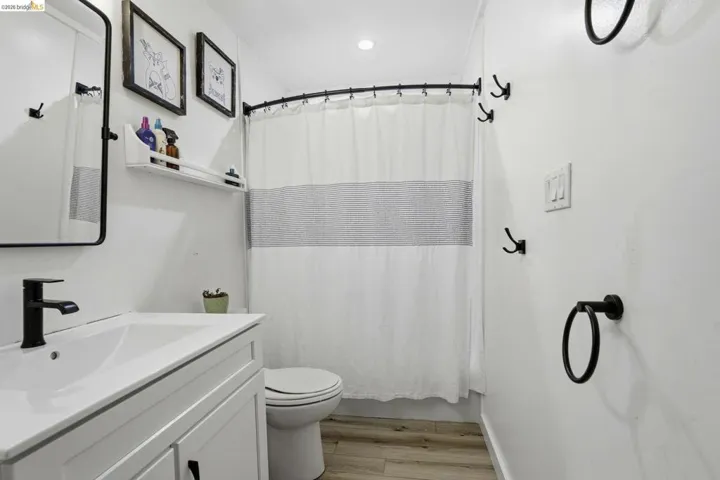 Full bathroom with light wood-style floors and vanity