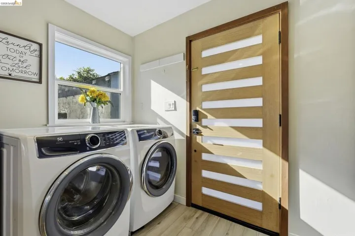 Laundry area with light wood-style floors and independent washer and dryer