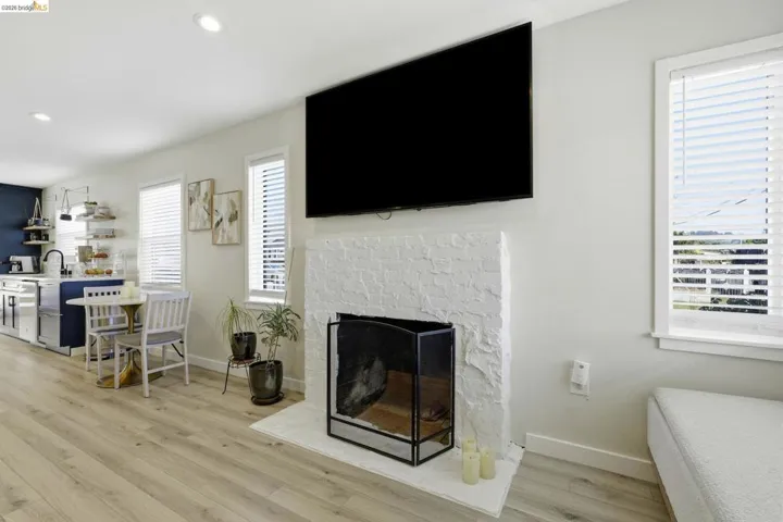 Living area with light wood-type flooring, a fireplace, and recessed lighting