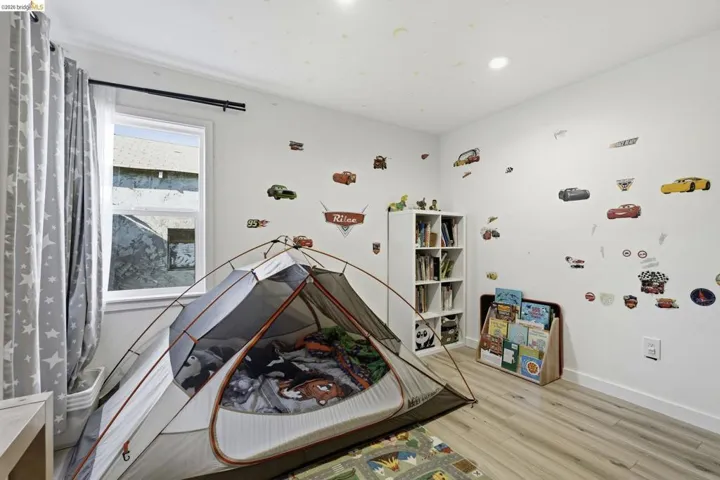 Recreation room featuring light wood-style flooring and baseboards