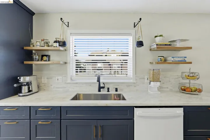 Bar featuring open shelves, dishwasher, and light stone counters