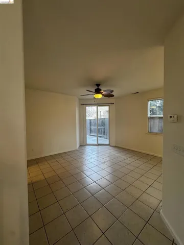 Unfurnished room with light tile patterned flooring and ceiling fan