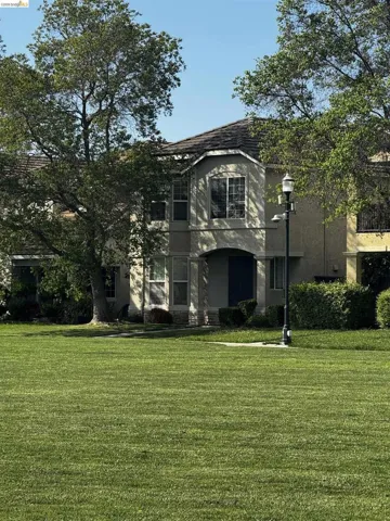 View of front facade featuring a front lawn and stucco siding