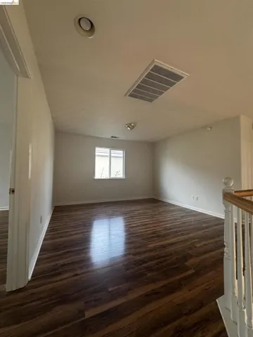 Unfurnished room with dark wood-type flooring