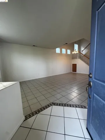 Unfurnished room with light tile patterned floors and baseboards