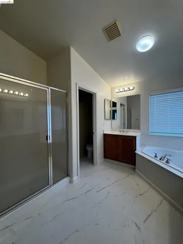 Full bathroom featuring vanity, a stall shower, and a bath