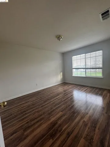 Empty room with dark wood-style flooring and a textured ceiling