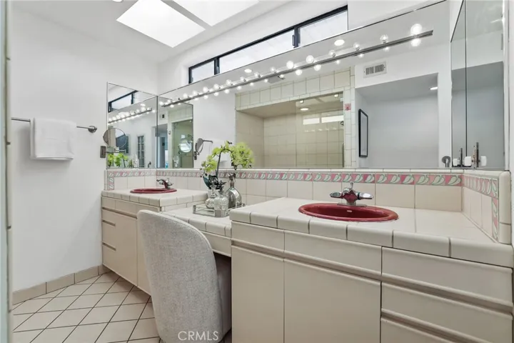 Unit #66 - Primary En Suite has double sink vanity and full length mirrored wall.