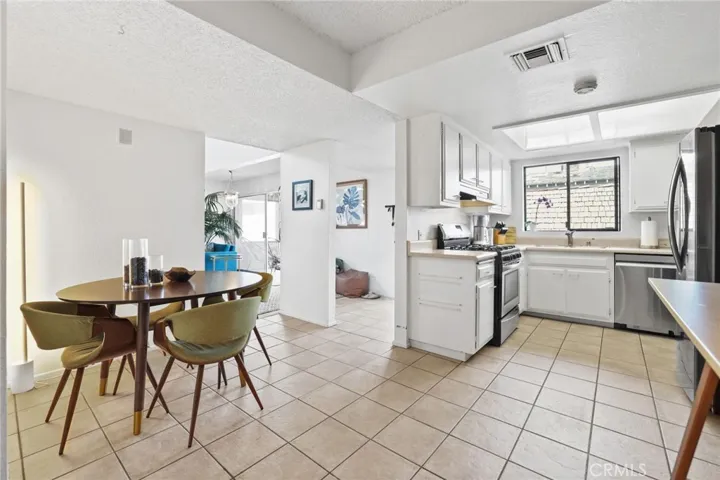 Unit #64 - Kitchen/eating area - gas stove range, dishwasher and refrigerator.