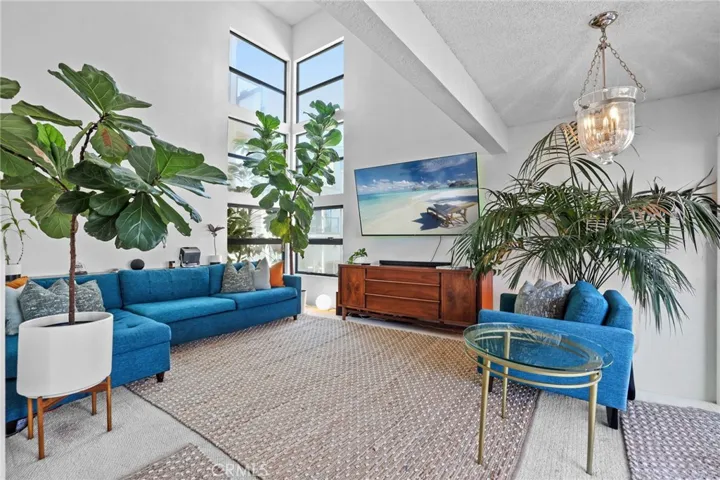 Unit #64 - Living room has two story ceiling with six panel full length windows for lots of natural light.
