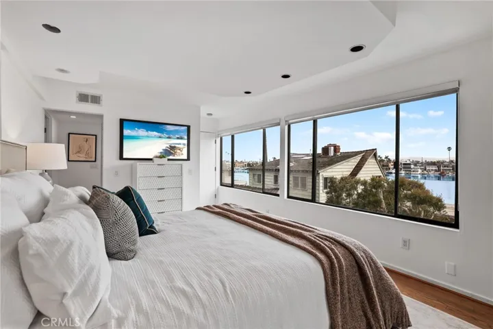 Unit #66 - Primary suite has recessed lighting, refinished hardwood floors and exterior door leading to balcony.