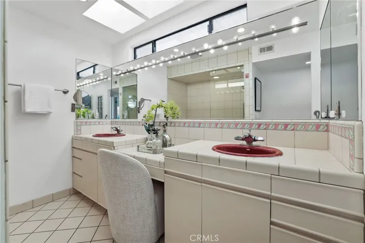 Unit #66 - Primary En Suite has double sink vanity and full length mirrored wall.