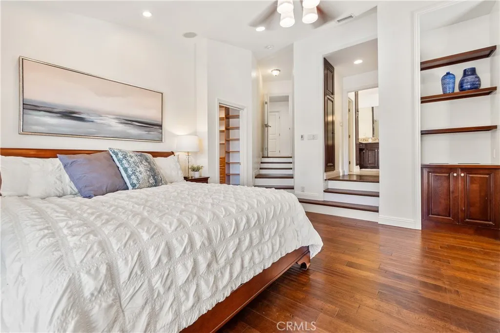 The Primary Bedroom suite is a retreat featuring beautiful built-in wood cabinetry, recessed lighting, and a spacious walk-in closet.