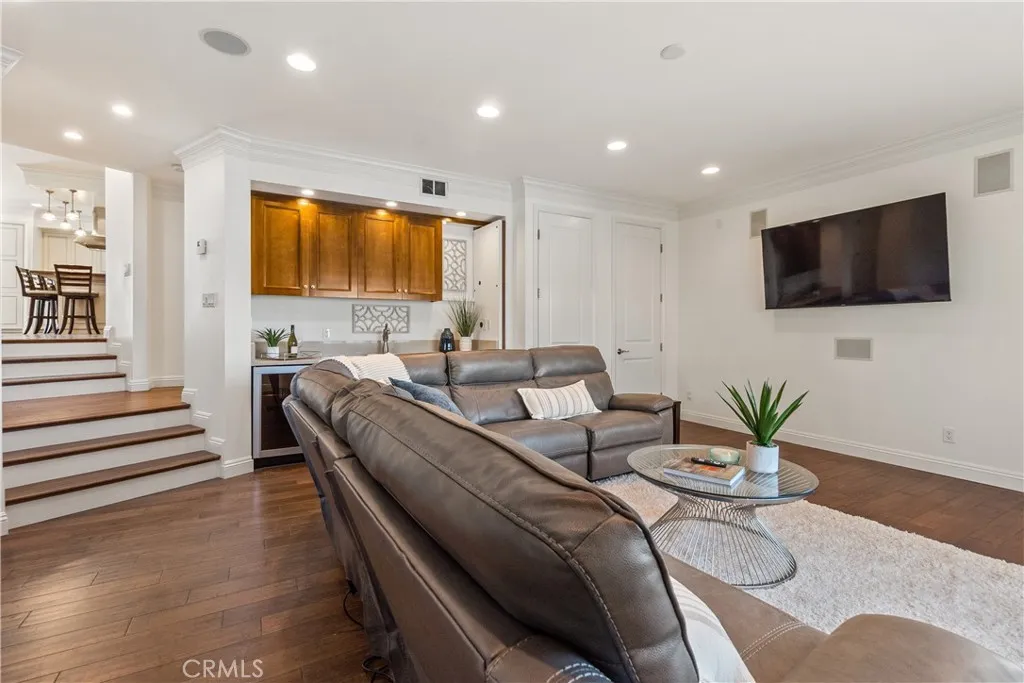 Well-designed living room with hardwood floors, built-in wet bar, and comfortable gathering spaces.