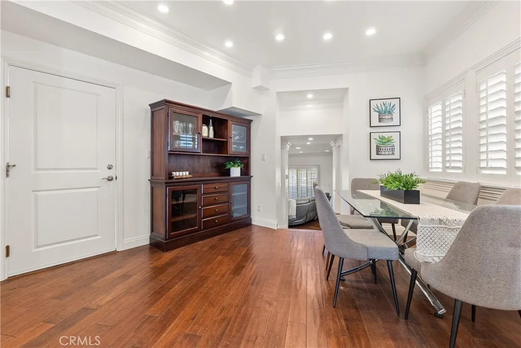 Bright and spacious dining area featuring hardwood floors, plantation shutters, and a comfortable setting for everyday dining or entertaining.