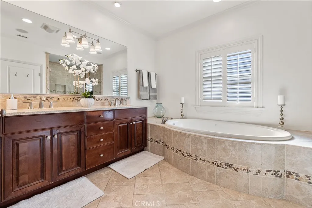 Luxurious primary bath designed as a relaxing retreat, featuring a soaking tub, glass-enclosed shower, and beautiful stone finishes.