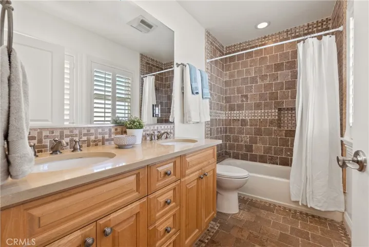 The spacious hallway bath with dual sinks at the vanity.