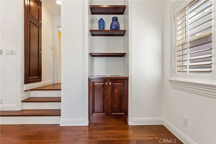 The Primary Bedroom suite is a retreat featuring beautiful built-in wood cabinetry, recessed lighting, and a spacious walk-in closet.