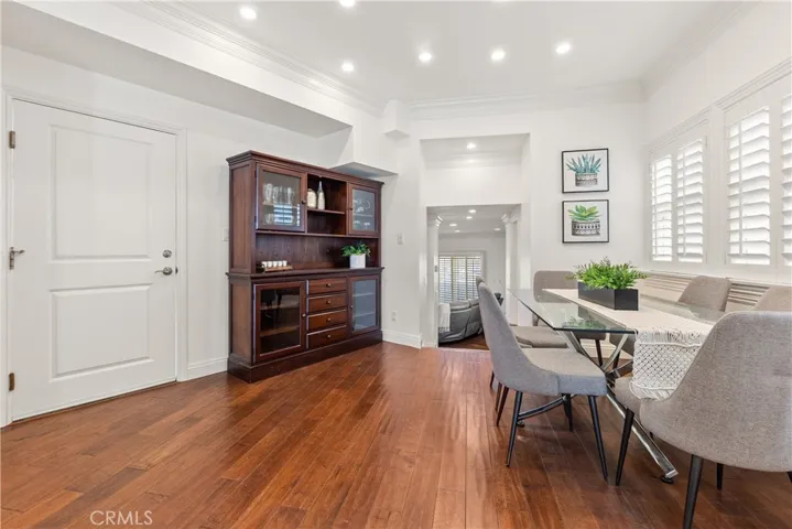 Bright and spacious dining area featuring hardwood floors, plantation shutters, and a comfortable setting for everyday dining or entertaining.