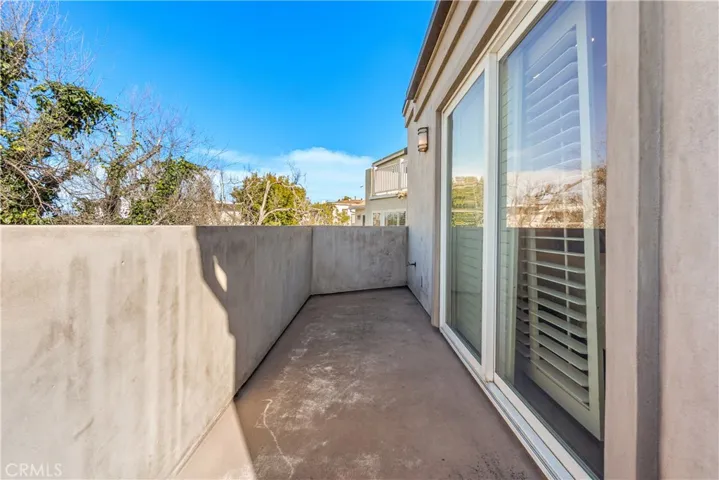Private balcony off the primary bedroom offering ocean views and coastal breezes.