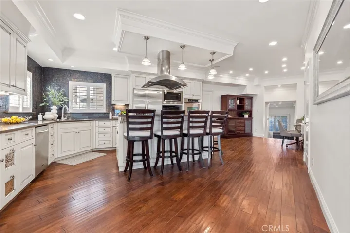 Elegant kitchen with stainless steel appliances and a spacious center island with integrated range and seating, thoughtfully designed for both entertaining and daily living.