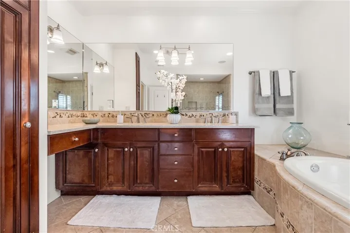 Luxurious primary bath designed as a relaxing retreat, featuring a soaking tub, glass-enclosed shower, and beautiful stone finishes.