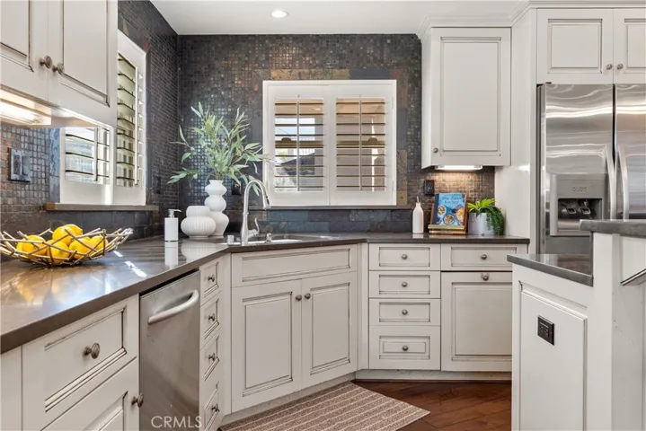 Inviting kitchen with detailed cabinetry, tile backsplash, and natural light.