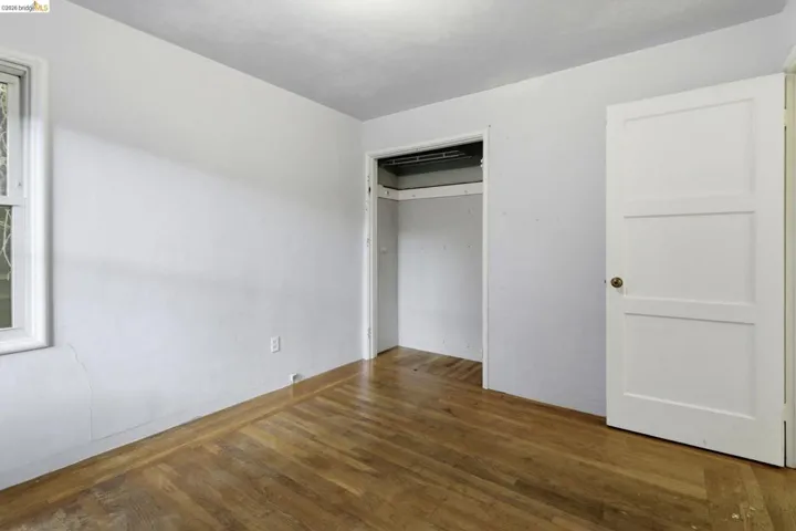 Unfurnished bedroom with dark wood finished floors and a closet