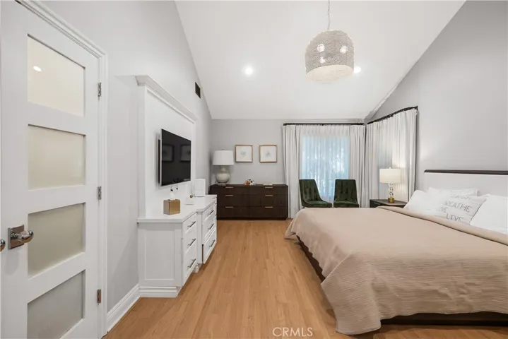 PRIMARY BEDROOM WITH VAULTED CEILINGS AND BUILT IN ENTERTAINMENT CENTER