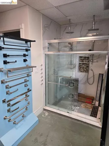 Full bath featuring a towel warmer and a marble finish shower