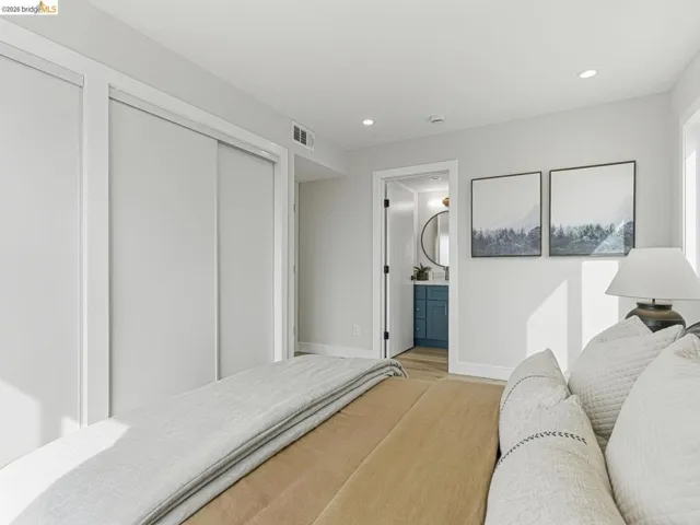 Bedroom featuring recessed lighting, light wood-style flooring, and ensuite bath