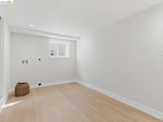 Laundry area featuring light wood finished floors, hookup for a washing machine, electric dryer hookup, and recessed lighting