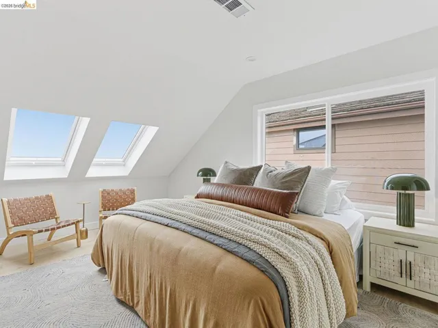 Bedroom featuring lofted ceiling, a skylight, and light wood-style flooring