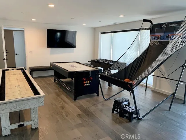 Game room with shuffleboard, foosball, pool table and basketball