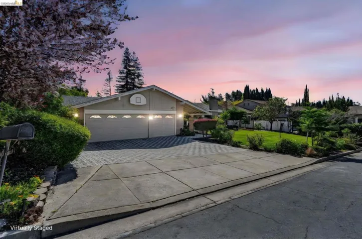 Ranch-style home featuring an attached garage, driveway, a lawn, and board and batten siding