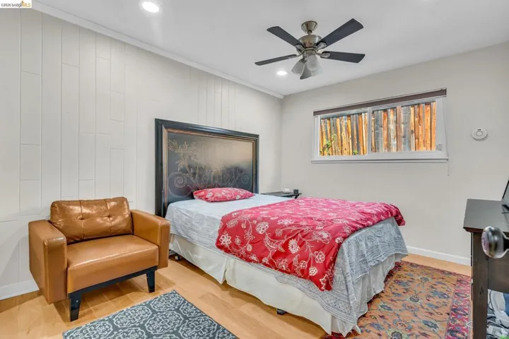 Bedroom with wood finished floors, ceiling fan, recessed lighting, and ornamental molding