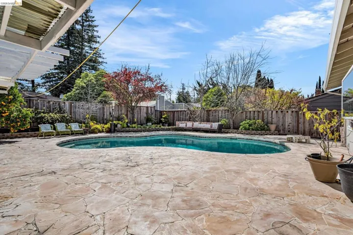 View of swimming pool featuring patio surround, a fenced backyard, and an outdoor lounge area