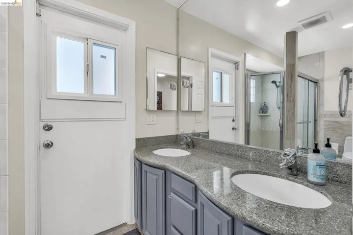 Bathroom featuring double vanity and a shower stall