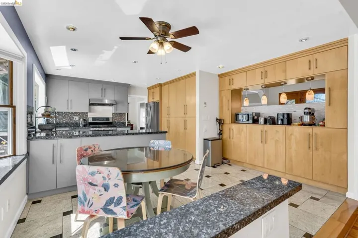 Kitchen with ceiling fan, a skylight, stainless steel appliances, backsplash, and recessed lighting