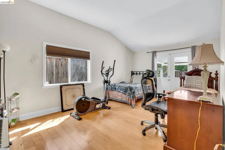 Bedroom featuring light wood finished floors and vaulted ceiling