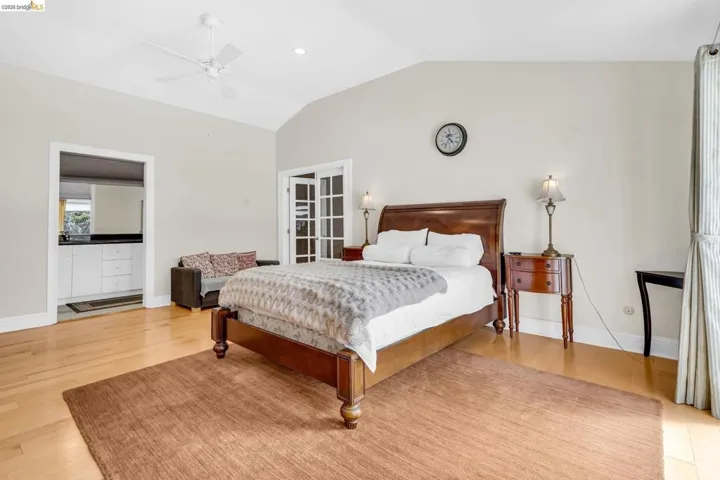 Bedroom with vaulted ceiling, light wood finished floors, a ceiling fan, and recessed lighting